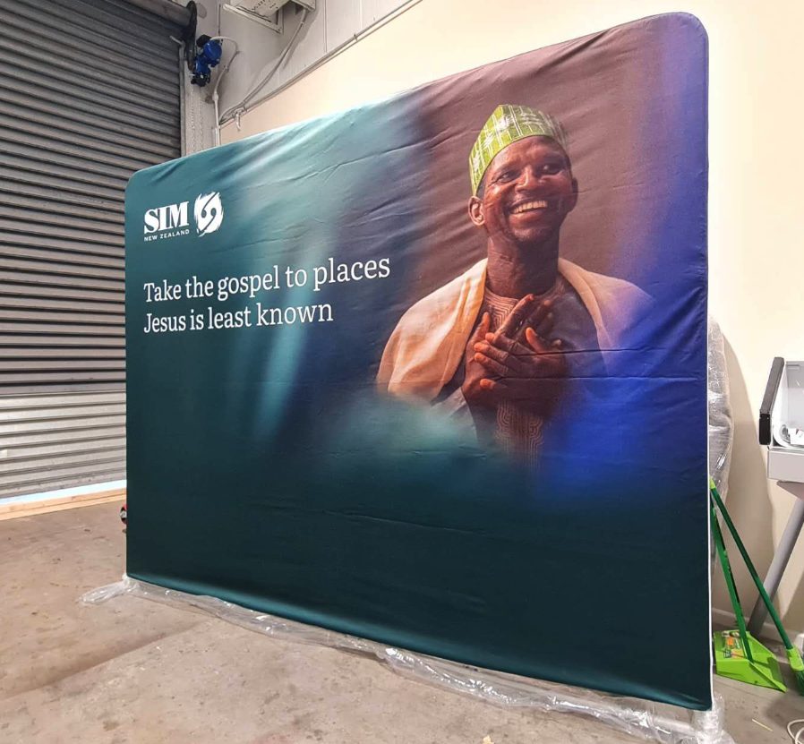 Fabric backdrop banner reading Take the gospel to places Jesus is least known