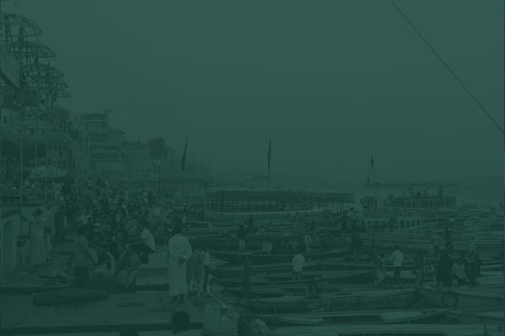 Crowds and boats along a river bank, toned Pounamu green